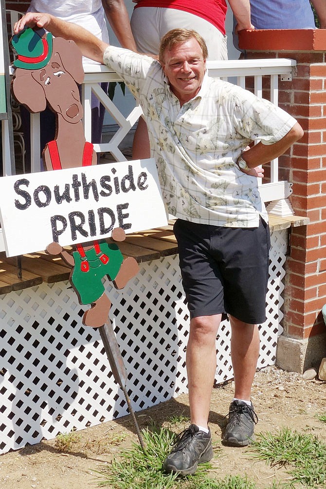 Chris Griggs poses with the Southside Pride yard sign he received Saturday morning, recognizing his property at 708 Washington St. as the first winner of the Old Munichburg Association Southside Pride Appearance Award.