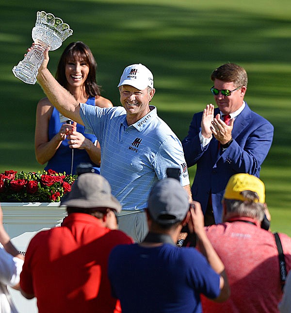 Retief Goosen raises the Sam Snead Trophy after winning the Bridgestone Senior Players Championship on Sunday at Firestone Country Club in Akron, Ohio.