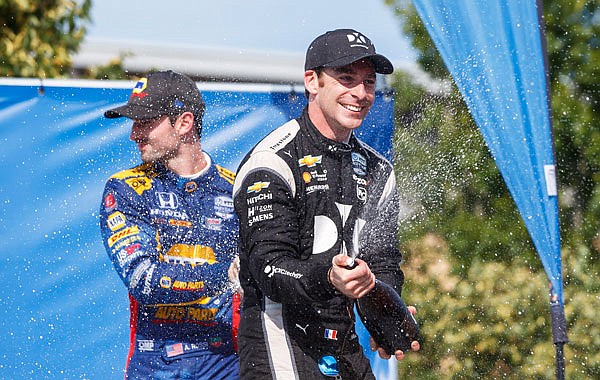 Simon Pagenaud (right) celebrates in the winner's circle after taking first place Sunday at the Honda Indy in Toronto.