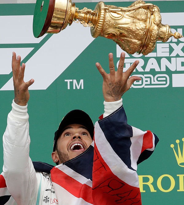 Mercedes driver Lewis Hamilton celebrates on the podium after winning the British Formula One Grand Prix on Sunday at the Silverstone racetrack in Silverstone, England.