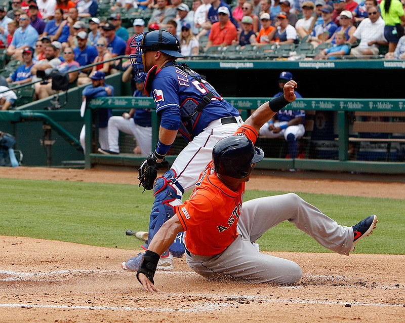 Houston Astros' Michael Brantley, right, scores ahead of the throw to Texas Rangers catcher Tim Federowicz in the first inning of a baseball game against the Texas Rangers, Sunday, July 14, 2019, in Arlington, Texas. (AP Photo/David Kent)