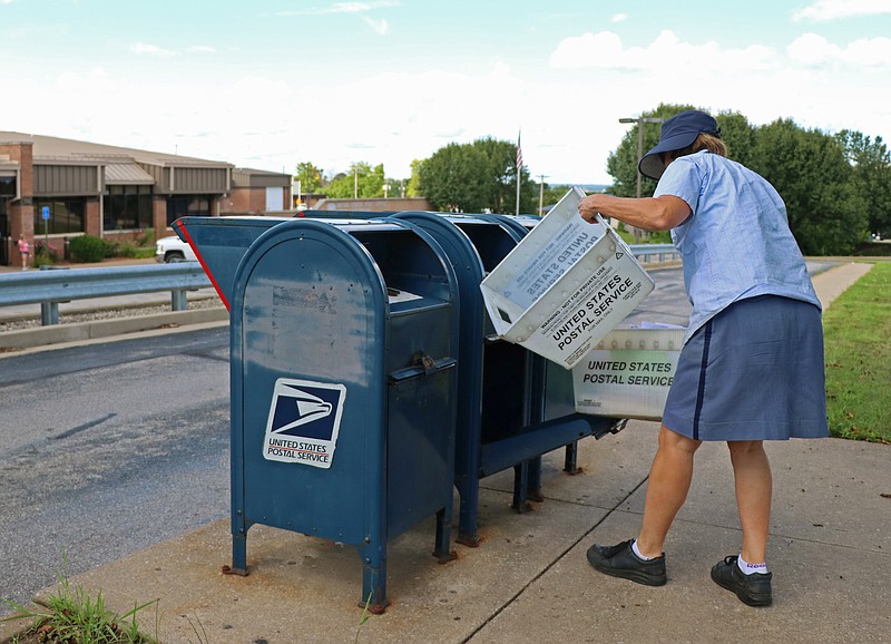 Greta Cross / News Tribune
Joan Keth with the United States Postal Service empties out the mailboxes located at the 1750 Jefferson Street Post Office Tuesday evening.