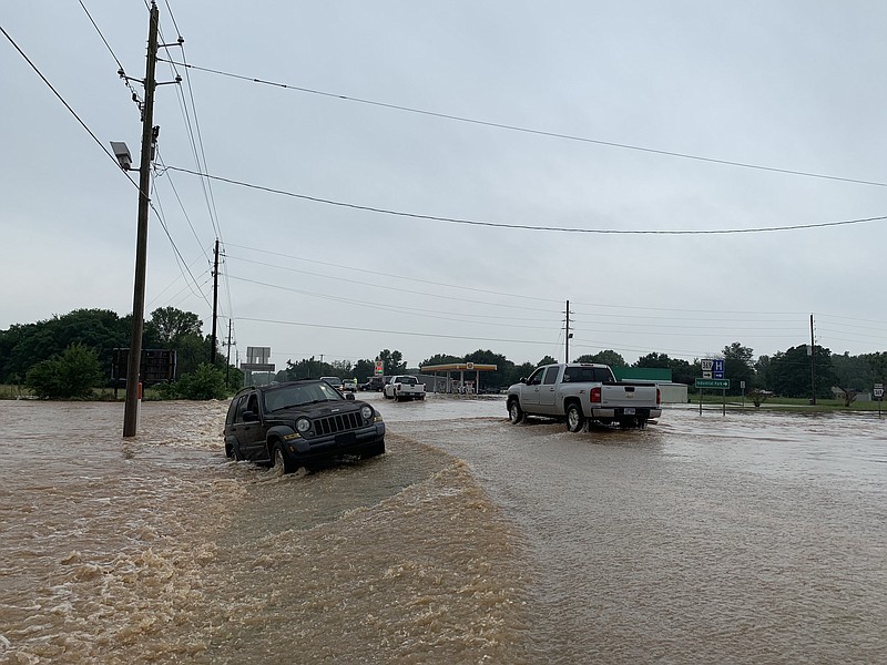 A Jeep Cherokee sits on the side of the Highway 27. It was pushed from the current of water on Tuesday, July 16, 2019, in Nashville, Arkansas. With water levels still rising, this portion of the highway has been shut down. 