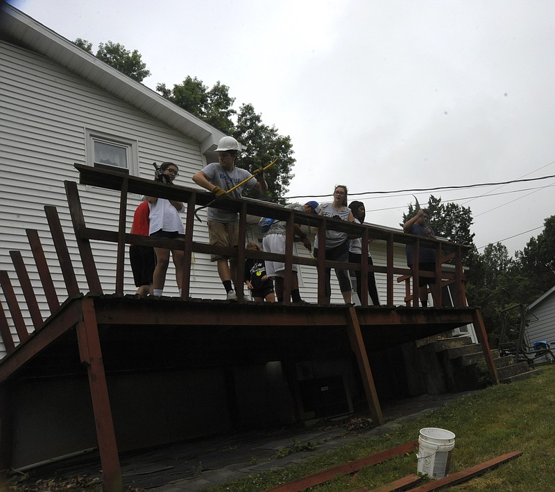 Youth with Mid-Missouri Mission Team tear down a deck at a California home Tuesday morning, July 16, 2019. Russellville resident Mason Deaver has worked service projects for two years. Working together on one task to get things done is what he enjoys most.