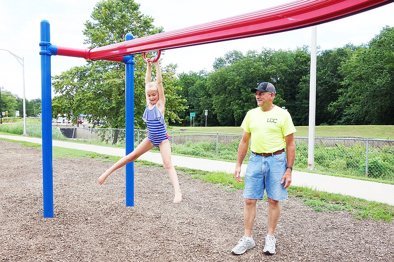 Kaylynn Carrender, 6, and grandfather Darrell Carrender, of Jefferson City, take a break from playing in the Fulton Splash Pad to catch a breeze on the zip line. With the heat index predicted to top 100 degrees this week, now's the time to plan cooling activities for your family.