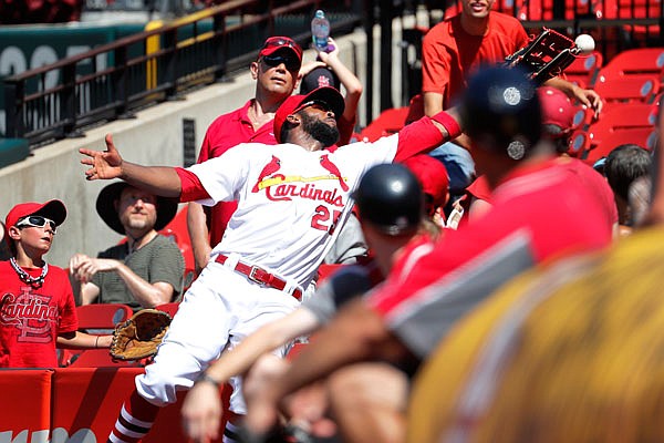 Cardinals right fielder Dexter Fowler dives into the stands but is unable to catch a foul ball hit by Starling Marte of the Pirates during the ninth inning of Wednesday afternoon's game at Busch Stadium.