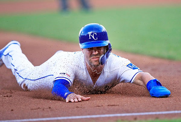 Whit Merrifield of the Royals slides into third base during the first inning of Wednesday night's game against the White Sox at Kauffman Stadium.