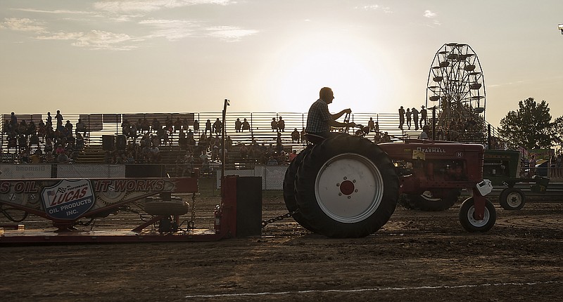 Stephanie Sidoti/News Tribune File Photo
A competitor in the Mid-Missouri Association of Tractor Pullers Antique Tractor Pull at the Cole County Fair pulls the weighted sled across the arena of the Jefferson City Jaycees Fairgrounds as the sun sets on Thursday, August 2, 2018.