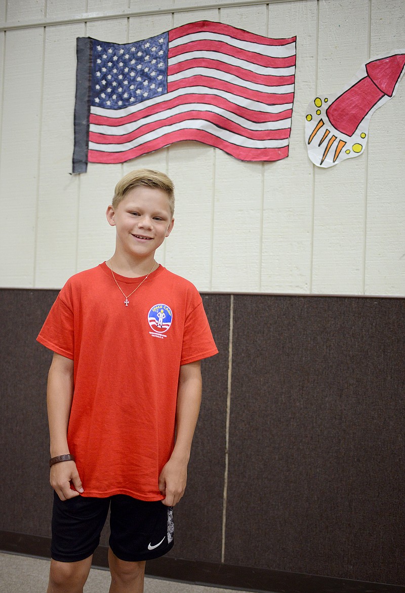 Sally Ince/ News Tribune
Maksim Protzman, 11, stands infront of an American flag Friday July 12, 2019 at Capital City Christian's daycare. For two summers Protzman has attended a Space Camp in Alabama.