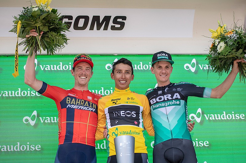 Egan Bernal from Colombia of Team Ineos, center, celebrates with Rohan Dennis from Australia of Bahrain-Merica Pro Cycling Team, left, and Patrick Konrad from Austria of Bora-Hansgrohe after winning the Tour de Suisse at the ninth and final stage, a 101.5 km race with start and finish in Goms, Switzerland, at the 83rd Tour de Suisse UCI ProTour cycling race, on Sunday, June 23, 2019. (Urs Flueeler/Keystone via AP)