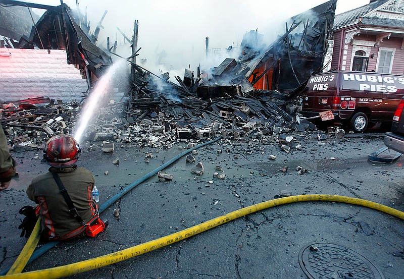 In a Friday, July 27, 2012 file photo, New Orleans firefighters work to put out a fire at Hubig's Pies in New Orleans. Louisiana's economic development office announced Thursday, July 18, 2019 that Hubig's Pies will be produced again in 2020 in suburban Jefferson Parish. (Catherine Threlkeld/The Times-Picayune/The New Orleans Advocate via AP)