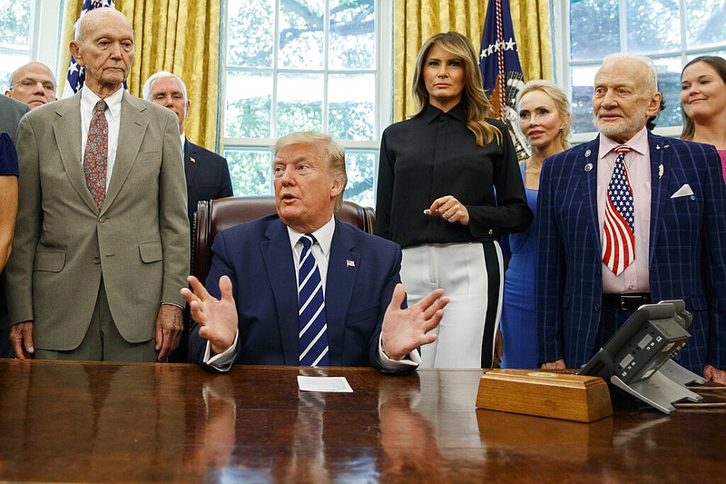 President Donald Trump, accompanied by Apollo 11 astronauts Michael Collins, left, and Buzz Aldrin, right, with Vice President Mike Pence and first lady Melania Trump, speaks during a photo opportunity commemorating the 50th anniversary of the Apollo 11 moon landing, in the Oval Office of the White House, Friday, July 19, 2019, in Washington. 