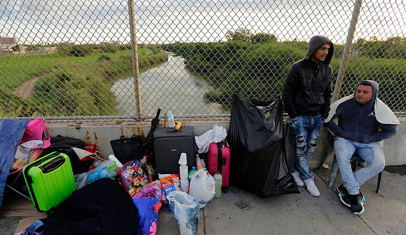 In this Nov. 2, 2018, file photo, Yenly Morales,left, and Yenly Herrera, right, immigrants from Cuba seeking asylum in the United States, wait on the Brownsville and Matamoros International Bridge in Matamoros, Mexico. The U.S. government will expand its policy requiring asylum seekers to wait outside the country in one of Mexico's most dangerous cities. According to officials for two congressional Democrats, the Department of Homeland Security says it will implement its "Migrant Protection Protocols" in Brownsville, Texas, across the border from Matamoros, Mexico. Matamoros is in Mexico's Tamaulipas state, which the U.S. government warns citizens not to visit due to violence and kidnappings.(AP Photo/Eric Gay, File)