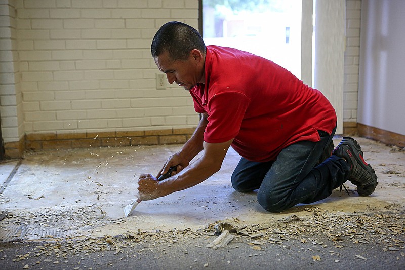 Rocky removes pieces off the old floor in the Nashville City Hall on Friday in Nashville, Ark. On Tuesday, Nashville was hit with a flash flood that damaged City Hall and several other buildings in the area. The majority of the businesses have already started to renovate the areas within the buildings that were damaged from the flood.