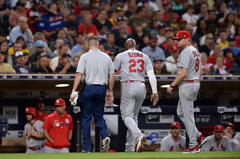 Marcell Ozuna (center) of the Cardinals leaves the field with an injury accompanied by a trainer and Mike Shildt during the third inning of a game against the San Diego Padres on Friday, June 28, in San Diego. 