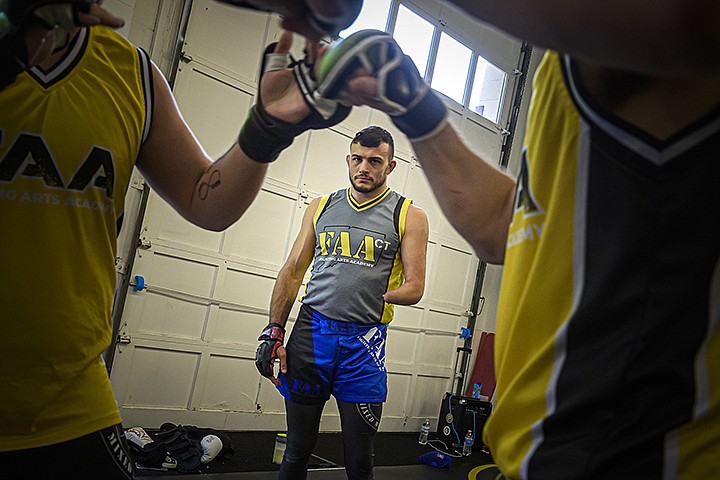 MMA fighter Nick Newell watches fighters in his West Haven gym. Born without a left arm below the elbow, the fighter has won 15 of his 17 matches. (Mark Mirko/Hartford Courant/TNS)
