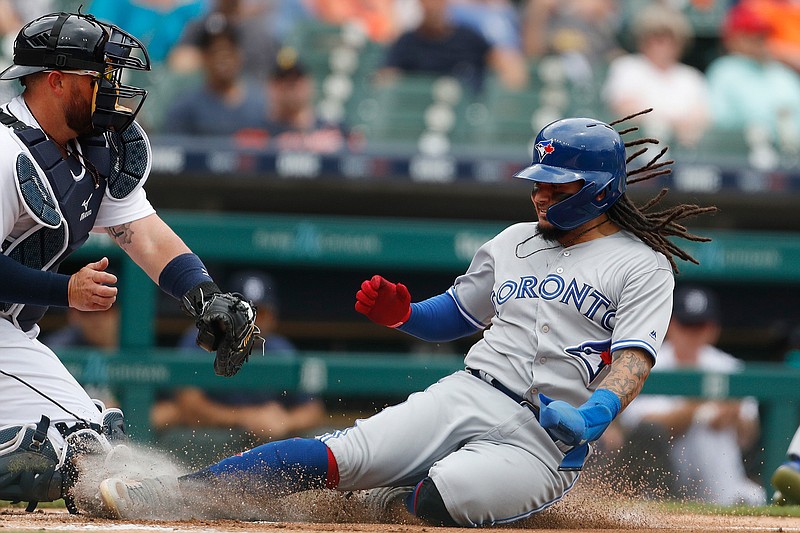 Toronto Blue Jays' Freddy Galvis, right, beats the throw to Detroit Tigers catcher Bobby Wilson to score from first on a double by teammate Lourdes Gurriel Jr. on Sunday in Detroit.