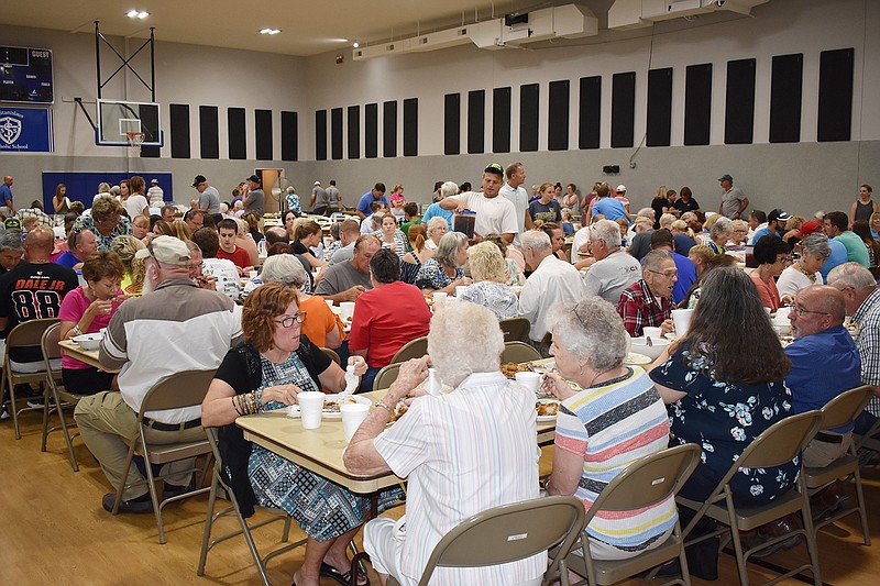 People congregate in the gym to eat a chicken and roast beef dinner during Sunday's St. Stanislaus Parish Picnic in Wardsville. The parish feeds about 3,200 people at the annual event.