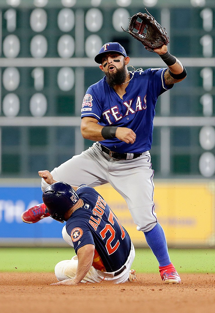 Texas Rangers second baseman Rougned Odor, top, jumps to avoid a slide by Houston Astros' Jose Altuve (27) after turning a double play at second base to end the seventh inning Sunday in Houston. 