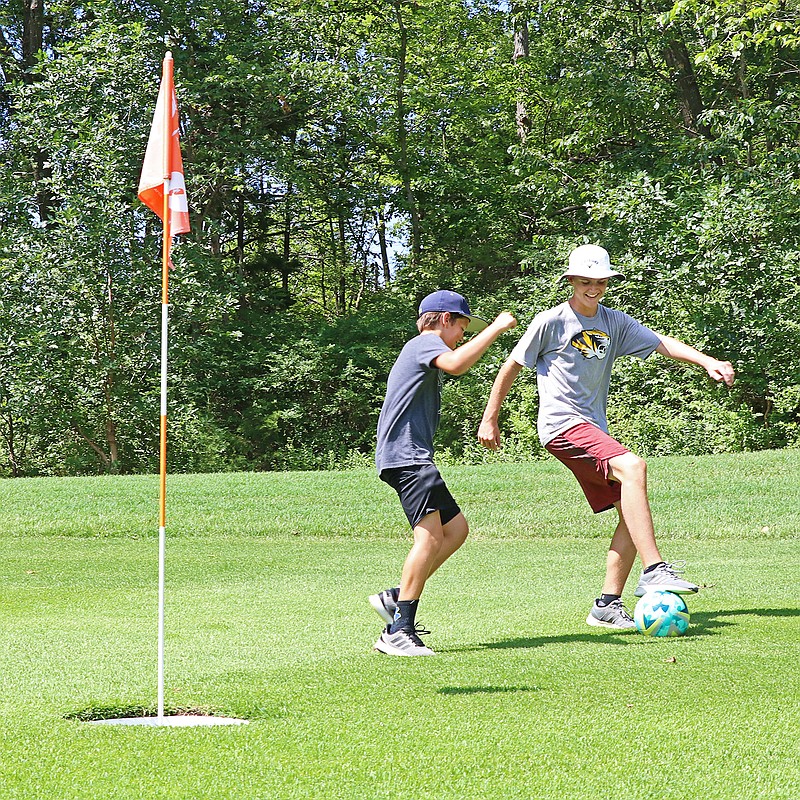 Evan McCullough, 12, left, and Dylan Bryan, 14, demonstrate a round of footgolf Monday at Oak Hills Golf Center. Footgolf is a mash-up of soccer and golf, where participants try to kick soccer balls into a hole in as few shots as possible. United Capital City Soccer and the Jefferson City Parks, Recreation and Forestry Department will host a footgolf tournament  
7 a.m.-6 p.m. Aug. 3 at the golf center.
