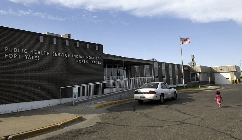 FILE - In this Oct. 14, 2008, a small child walks toward the front door of the Public Health Service Indian Hospital on the Standing Rock Reservation in Fort Yates. N.D.  A federal audit released Monday, July 22, 2019, finds that government hospitals placed Native Americans at increased risk for opioid abuse and overdoses. The audit says a handful of Indian Health Service hospitals, including the Fort Yates Hospital, failed to follow the agency’s protocols for dispensing and prescribing the drug. The Indian Health Service agreed with the more than a dozen recommendations and says changes are in the works. (AP Photo/Will Kincaid, File)