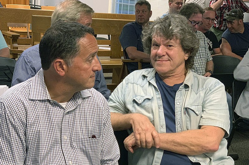 FILE - In this Tuesday, July 16, 2019, file photo, Michael Lang, right, Woodstock 50 co-producer and co-founder, sits in Vernon Town Hall before a planning board hearing in Vernon, N.Y., for his appeal to grant a permit for the Woodstock 50 music festival. Woodstock 50 organizers have again been denied a permit to hold a three-day festival at an upstate New York horse track. Town of Vernon officials say Monday, July 22, 2019, the permit application for a festival Aug. 16-18 at the Vernon Downs racetrack and casino was filed too late and was rife with problems. (Edward Harris/Observer-Dispatch via AP)