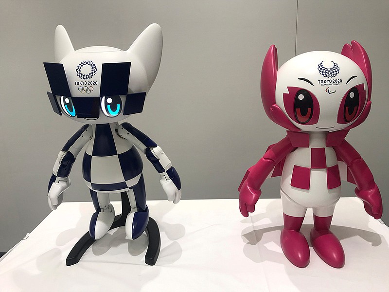 In this Thursday, July 18, 2019, photo, robots of mascots of Olympics "Miraitowa," left, and Paralympics "Someity" are shown to the media at Toyota Motor Corp. headquarters in Tokyo. The mascot robots' eyes change to the images of stars and hearts. The Japanese automaker Toyota, a major Olympic sponsor, is readying various robots for next year's Tokyo Olympics. (AP Photo/Yuri Kageyama)