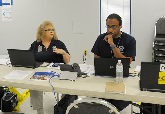 JULY 24, 2019, PHOTO: Glenda Breeding, FEMA disaster recovery manager, and Mitchell Jackson, housing crew lead, work the temporary disaster recovery center in Eldon with a few other team members. 