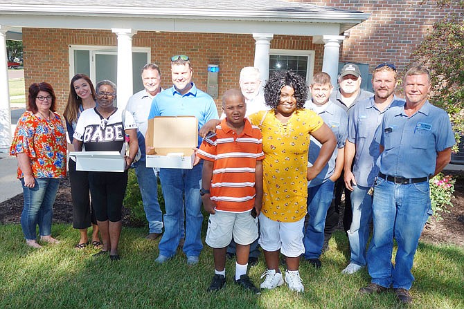 Members of the community, including representatives from Westminster College, Central Missouri Community Action and others, rallied to help Leah Martin (in "babe" shirt), her husband Robert (not pictured), daughter Rebe Jackson (yellow shirt) and grandson Cameron Evans (striped polo) get back on their feet after the flood. On Tuesday, they celebrated finding long-term housing with doughnuts from Jamolee's.