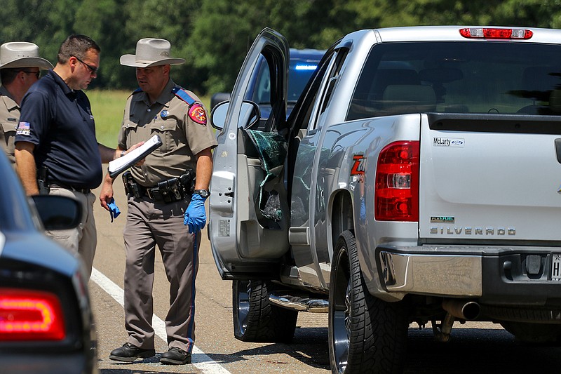 Texas state troopers and Nash police officers investigate the crime scene where a vehicle pursuit ended Thursday on Interstate 30 near New Boston. The chase began in Nash. The suspect's vehicle was stopped with the help of other law enforcement and the use of a tire deflation device. Police say the suspect suffered from a self-inflicted gunshot wound and later died in the hospital.