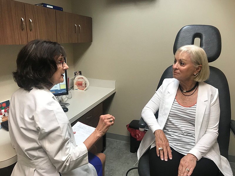 In this Wednesday, July 17, 2019, photo, Laurie Barber, a Little Rock, Ark., ophthalmologist, talks with patient Carolyn Lay at the Little Rock Eye Clinic. Barber chairs a group that wants to hold a referendum on a new Arkansas law that expands the procedures that optometrists can perform.  Arkansas optometrists who say they have to refer patients sometimes as far as an hour away successfully urged the Legislature this year to expand what procedures they can perform. But that change sparked an expensive and heated lobbying fight, and now faces the prospect of going before voters next year. (AP Photo/Andrew DeMillo)