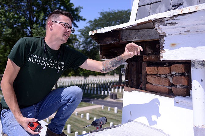 Restoration specialist Joseph Jisa points out an exposed section of the soffit that needs repairing Saturday during a volunteer rehab session at the Jefferson City National Cemetery old Caretaker's Cottage. The Historic City of Jefferson and the U.S. Department of Veterans Affairs are working to rehabilitate the cottage to be leased by the HCJ for the next five years.