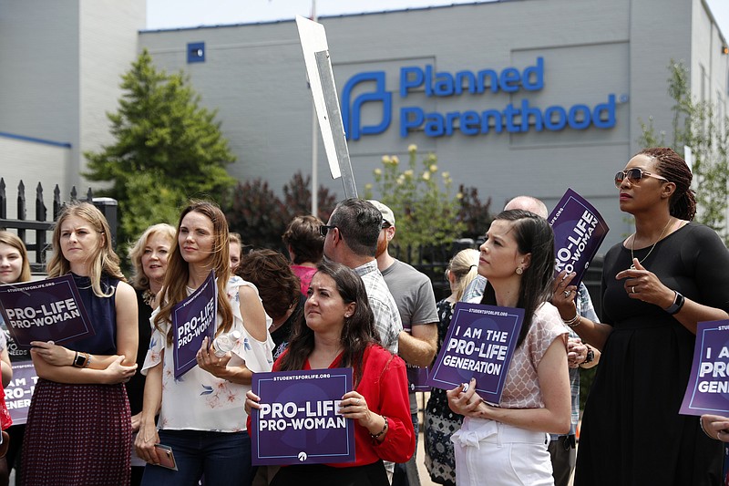 FILE - In this June 4, 2019, file photo, Anti-abortion advocates gather outside the Planned Parenthood clinic in St. Louis. Planned Parenthood and the American Civil Liberties Union filed a lawsuit Tuesday, July 30, against the state of Missouri to stop a law that bans abortions beyond the eighth week of pregnancy from taking effect Aug. 28. (AP Photo/Jeff Roberson, File)