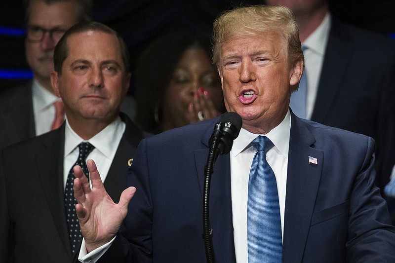 FILE - In this Wednesday, July 10, 2019, file photo, President Donald Trump speaks about kidney health, accompanied by Health and Human Services Secretary Alex Azar, left, in Washington. Azar says he and Trump are working on a plan to allow Americans to import lower-priced prescription drugs from Canada. (AP Photo/Alex Brandon, File)
