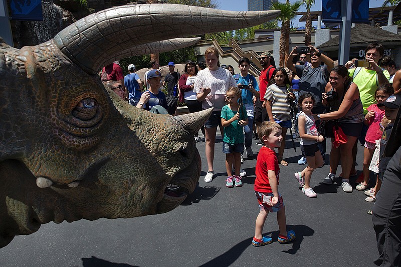 Spectators take photos of the trisaurus "Juliet" at Jurassic Park at Universal Studios Hollywood in Universal City, Calif. on Wednesday, July 17, 2019. (Liz Moughon / Los Angeles Times/TNS)