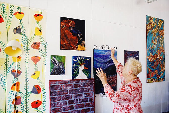 Virginia "Ginny" Starke shows some of her paintings that she has around Arthur Studio & Gallery. Starke wants her murals to be the only art of hers in the studio while the rest would be contributed from outside artists.