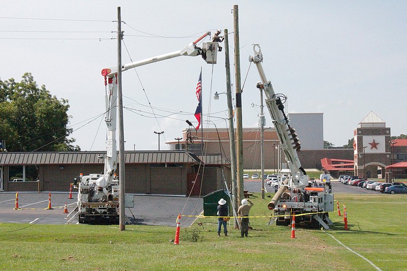 SWEPCO employees work to restore power to Texarkana Independent School District administration offices on Thursday. 