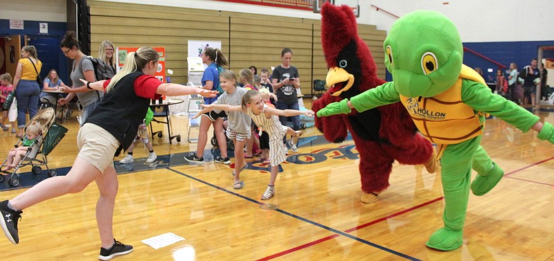<p>Democrat photo/Liz Morales</p><p>Mary Blochberger, an athletic trainer with Capital Region Healthplex West, sets the pace and stances for yoga July 30 with her impromptu class of incoming Tipton students and two mascots for moral support at the Back to School Fair at California High School.</p>