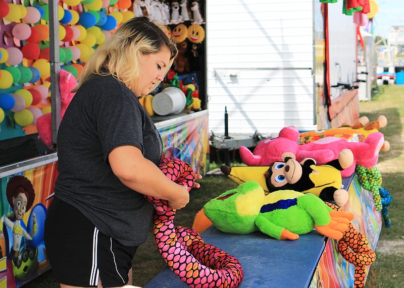 
Amber Davis with Sunshine Amusement Company prepares her game stand for Friday night events at the 2019 Jefferson City Jaycees Cole County Fair.  

