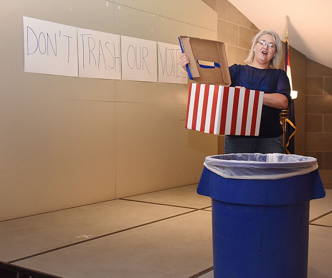 With the theme of Friday's pro-choice rally being "don't trash our vote," Holly Bickmeyer, a volunteer with the ACLU, empties the box of ballots into the trash can to emphasize that point. Nearly two dozen supporters were in attendance Friday during the noon rally in the Capitol Rotunda, an event that was hosted by multiple pro-choice organizations.