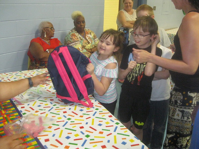 Children joyously receive school backpacks during the three-hour Back to School Bash held Saturday at the Southwest Center in Texarkana,Texas. Shalonda Washington and her husband, Tarvaris, who were born and raised on the Texas side, are now former Twin Cities residents. The couple bought the backpacks and school supplies for children as a way of serving their former hometown.