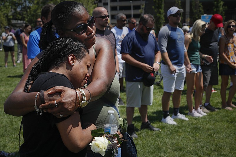 Mourners gather at a vigil following a nearby mass shooting, Sunday, Aug. 4, 2019, in Dayton, Ohio. Multiple people in Ohio have been killed in the second mass shooting in the U.S. in less than 24 hours, and the suspected shooter is also deceased, police said. (AP Photo/John Minchillo)