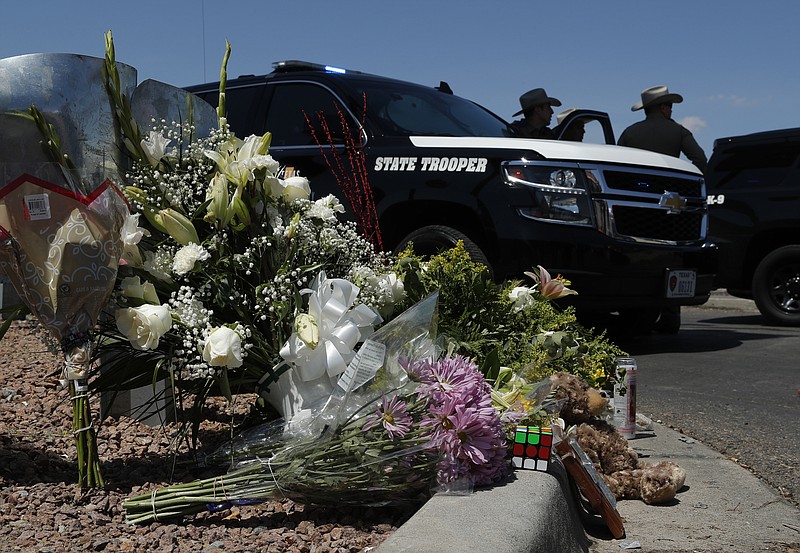Flowers adorn a makeshift memorial near the scene of a mass shooting at a shopping complex Sunday, Aug. 4, 2019, in El Paso, Texas. (AP Photo/John Locher)