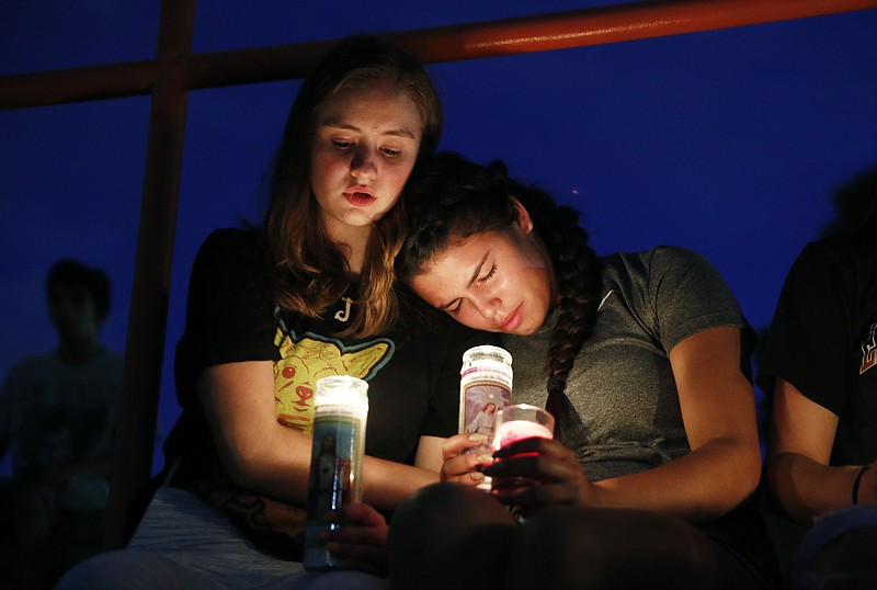 Melody Stout and Hannah Payan comfort each other during a vigil for victims of the shooting that occurred earlier in the day at a shopping center, Saturday, Aug. 3, 2019, in El Paso, Texas. (AP Photo/John Locher)