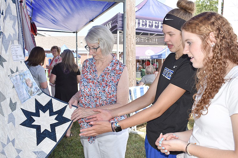 From left, Virginia Holtmeyer shows a quilt to sisters Adalyn and Taylor Koelling at Sunday's St. Margaret of Antioch Catholic Church in Osage Bend. Holtmeyer's daughter, Charlotte Braun, worked on the quilt before dying of cancer in late July.