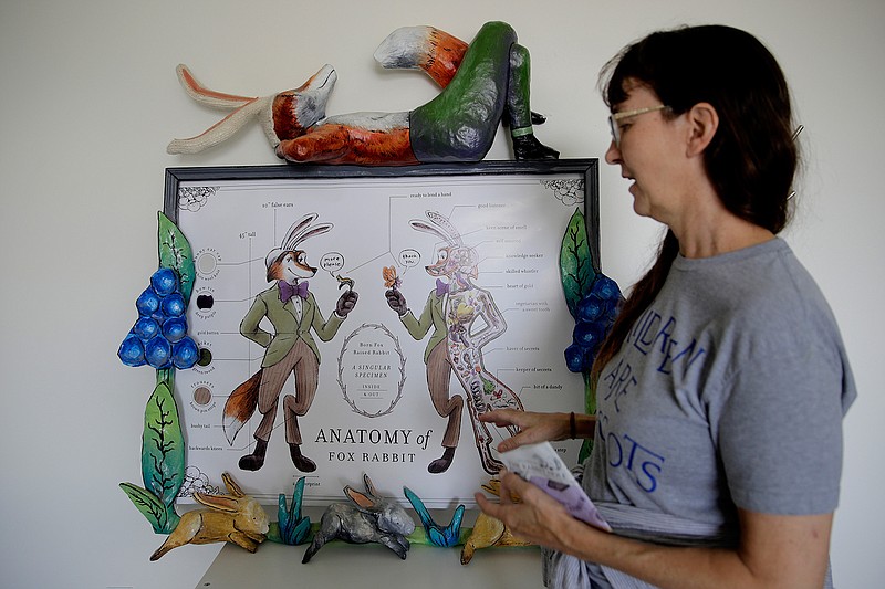 In this photo taken Thursday, Aug. 1, 2019, Debbie Pettid, talks about Fox Rabbit, the character created to represent the Inside the Rabbit Hole children's book museum in North Kansas City, Mo. Pettid and her husband Pete Cowdin closed their children's bookstore to start the museum located in an old warehouse. (AP Photo/Charlie Riedel)