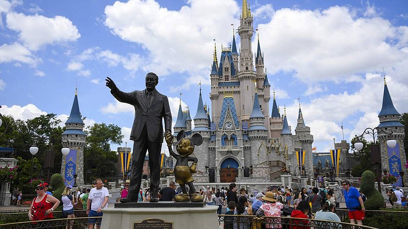 Guests watch a show near a statue of Walt Disney and Mickey Mouse at Walt Disney World in Lake Buena Vista, Fla. (Allie Goulding/Tampa Bay Times/TNS)