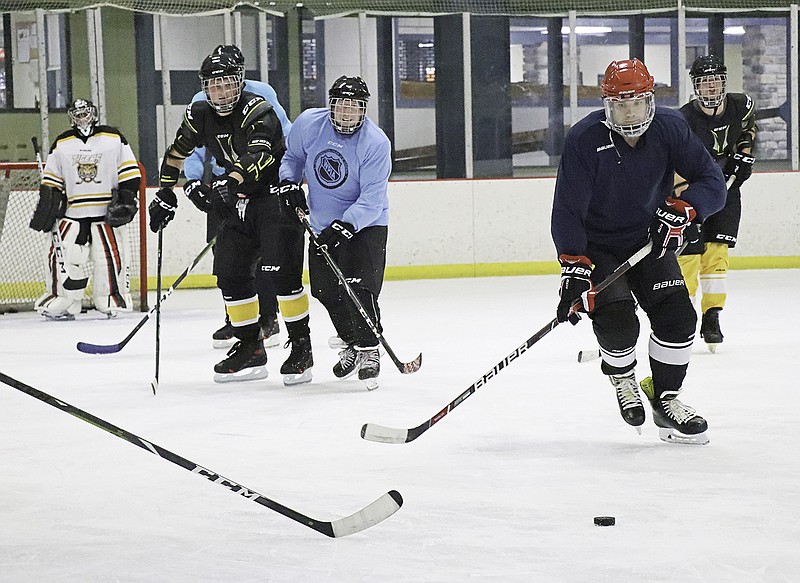 Jon Pagel, right, with the Jefferson City Fire Department runs after the puck during Guns N Hoses hockey practice Monday at Washington Park Ice Arena. The Jefferson City police and fire department unions will host a hockey game fundraiser at 7 p.m. Aug. 24 at the arena.