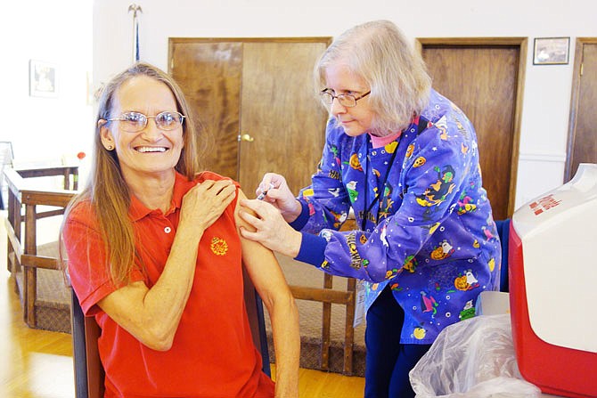 Pat Grabb, assistant cook at the Callaway County Senior Center, grins as Callaway County Health Department registered nurse Nancy Russell gives her a flu shot. Walk-in vaccinations will be available through August on Mondays and Fridays, along with appointments on Wednesdays, at the University of Missouri Extension in Fulton.