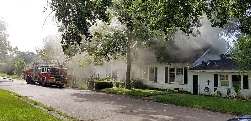 Texas-side firefighters respond to a house fire at the corner of Magnolia and West. The fire apparently started in the main room and made its way up to the attic by the time firefighters had it under control. (Staff photo by Jason Hopkins)